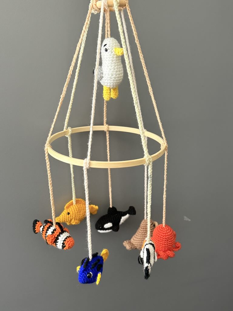 handmade crochet baby mobile featuring whales, seals, fish, and octopus toys