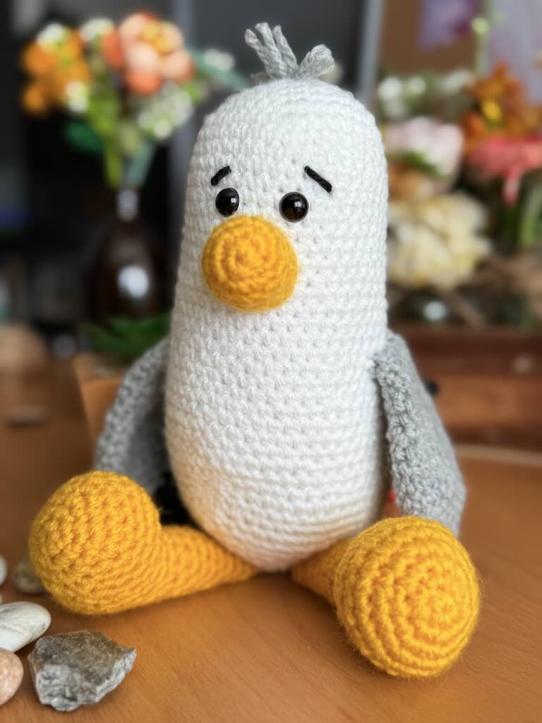 handmade crochet seagull with yellow beak, white wings, and friendly eyes