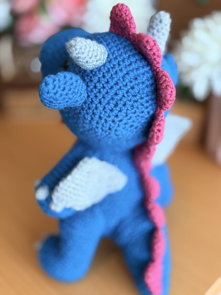 crochet fire-breathing dragon toy with pink tummy and cheerful expression