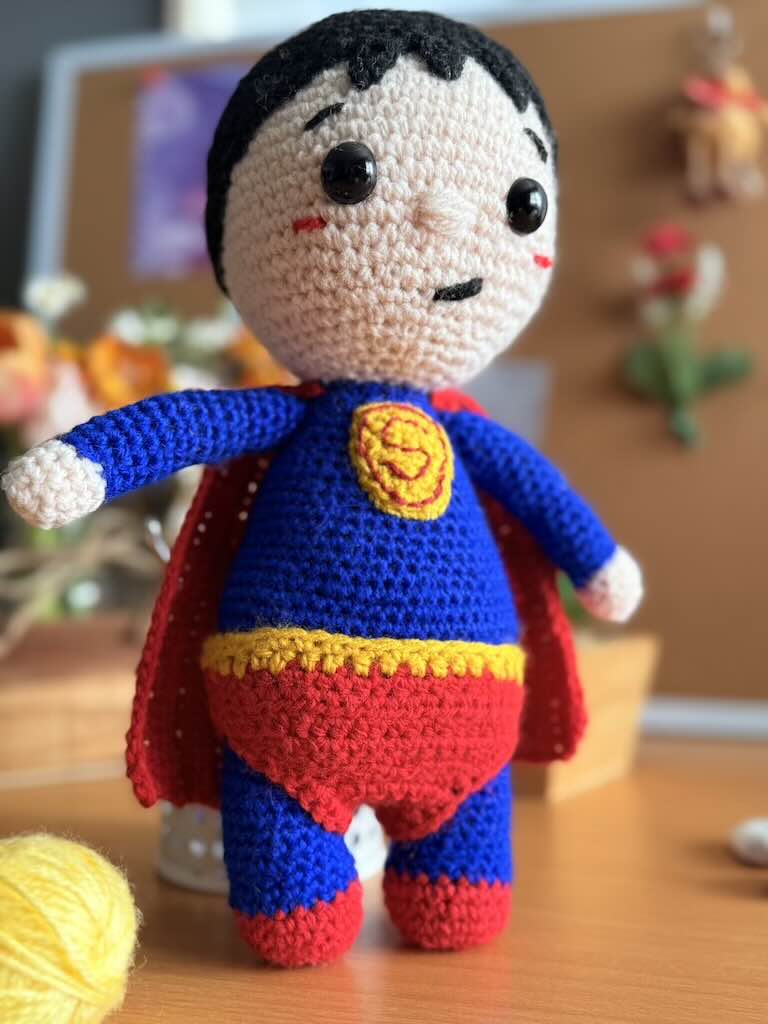 handmade crochet superhero toy dressed as Superman with cape and emblem