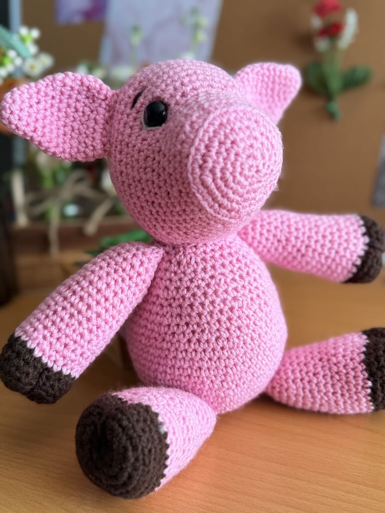 cute handmade crochet pink piggy with round body and friendly face