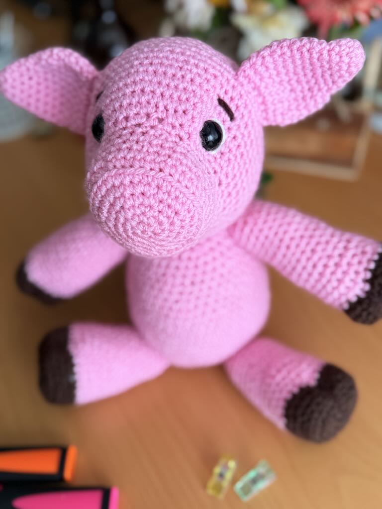 cute handmade crochet pink piggy with round body and friendly face
