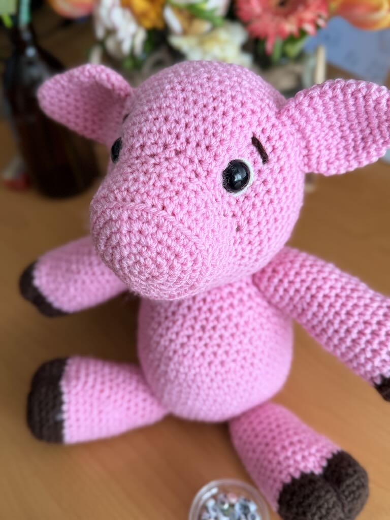 cute handmade crochet pink piggy with round body and friendly face
