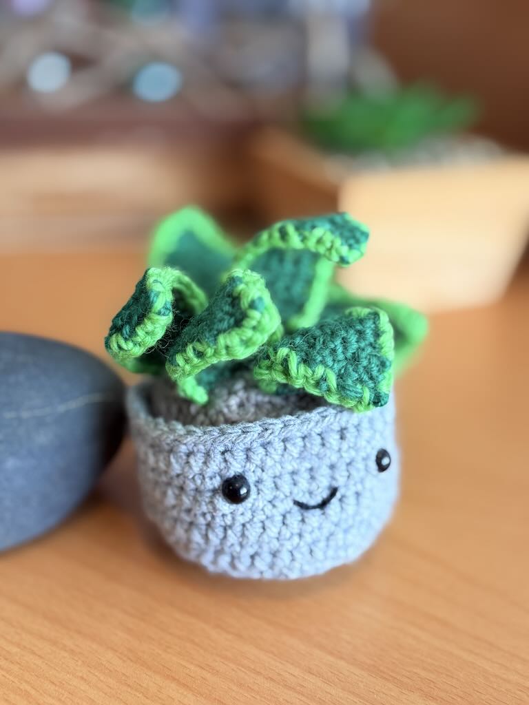 handmade crochet snake plant in a small pot with tall green leaves