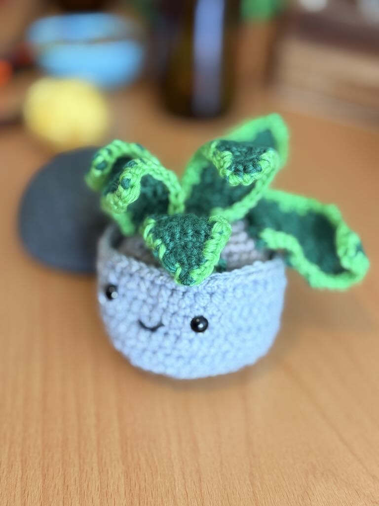 handmade crochet snake plant in a small pot with tall green leaves