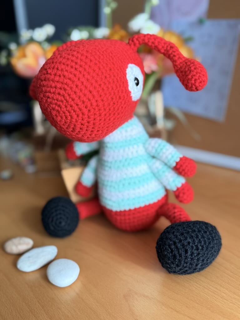 handmade crochet worker ant toy named Antony with tiny legs and stripey jumper