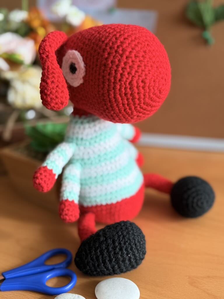 handmade crochet worker ant toy named Antony with tiny legs and stripey jumper