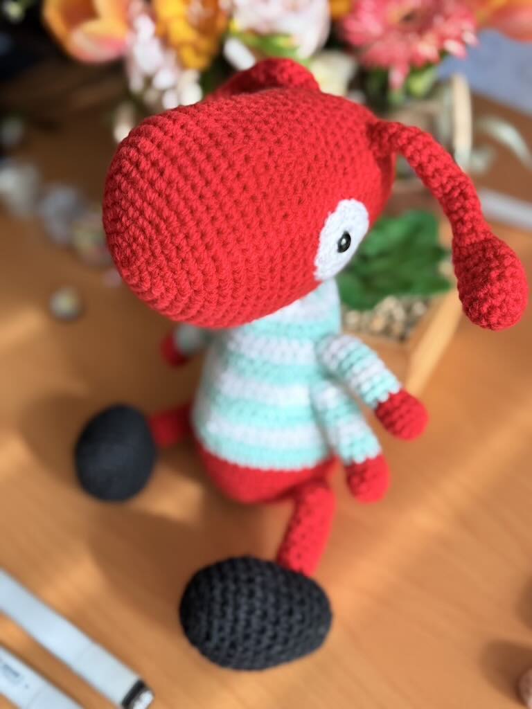 handmade crochet worker ant toy named Antony with tiny legs and stripey jumper