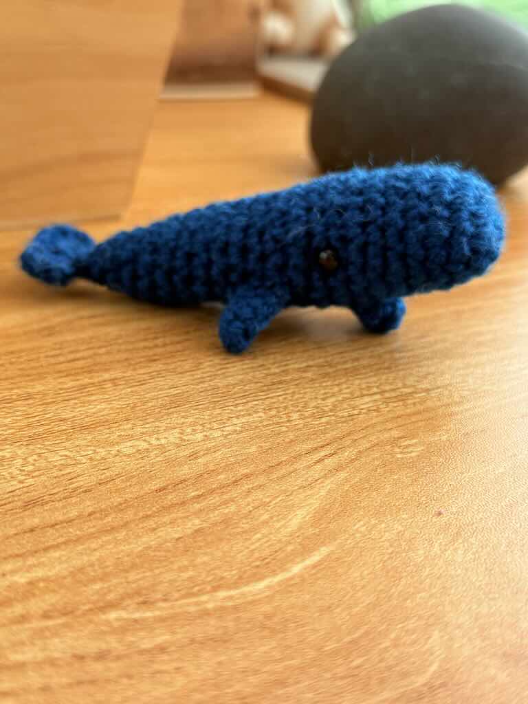 handmade crochet mini whale named Bluey with blue yarn and friendly smile