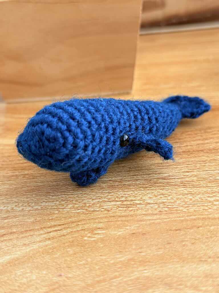 handmade crochet mini whale named Bluey with blue yarn and friendly smile