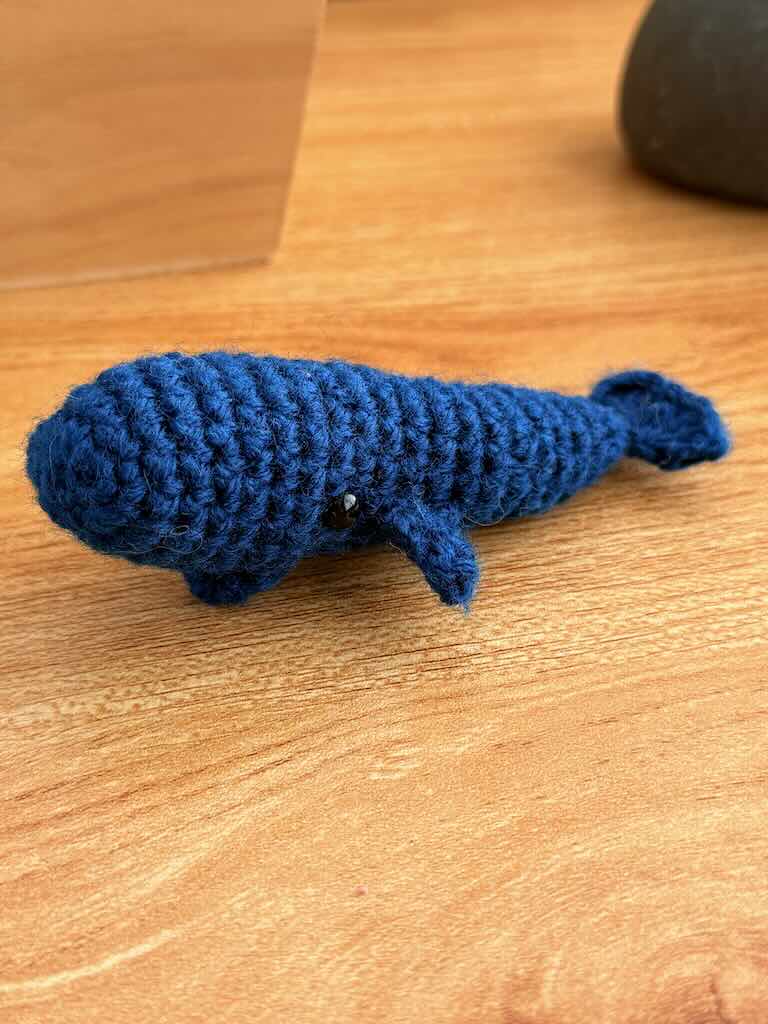 handmade crochet mini whale named Bluey with blue yarn and friendly smile