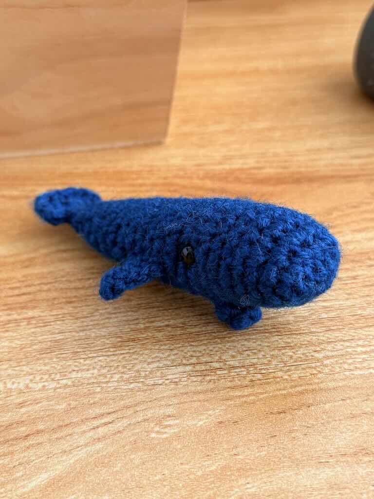 handmade crochet mini whale named Bluey with blue yarn and friendly smile