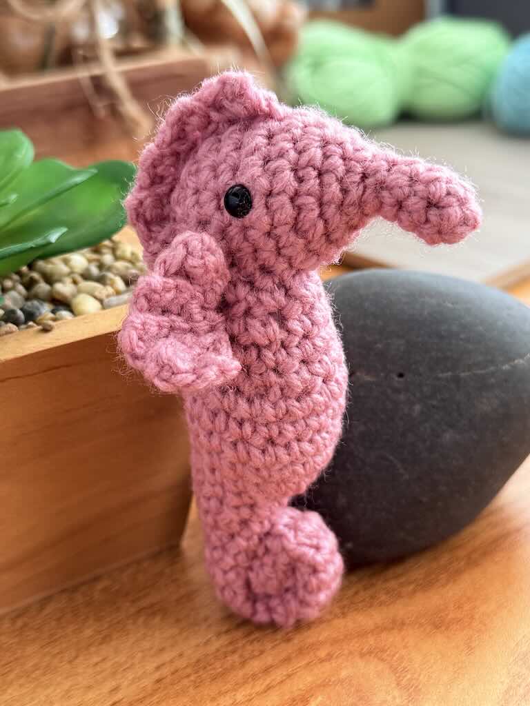 handmade crochet seahorse toy named Saul with curly tail and delicate pink fins