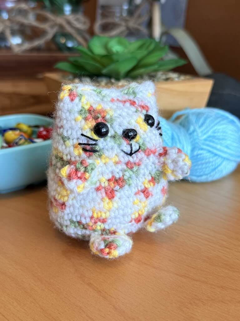 handmade crochet cat named Pookie with soft white body and colorful fur
