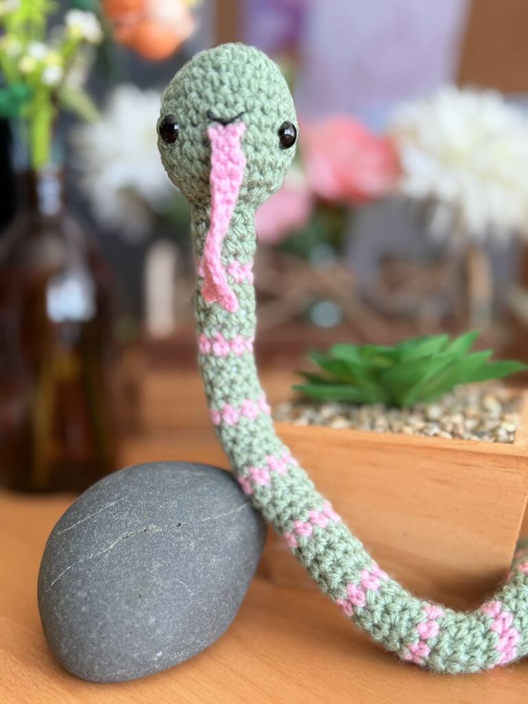 handmade crochet snake toy named Slither with long body and playful face