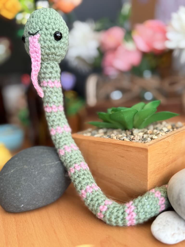 handmade crochet snake toy named Slither with long body and playful face