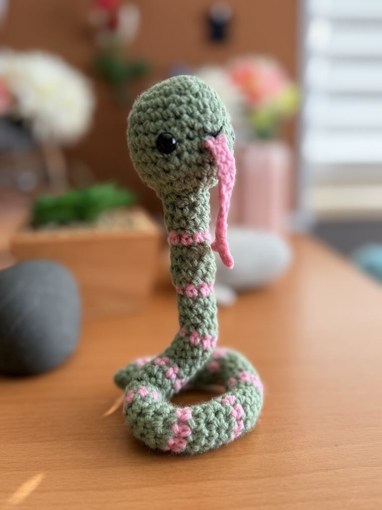 handmade crochet snake toy named Slither with long body and playful face