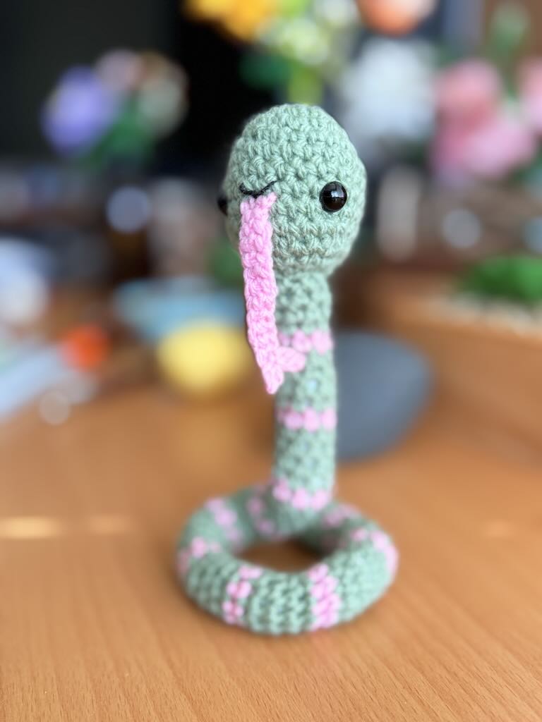 handmade crochet snake toy named Slither with long body and playful face