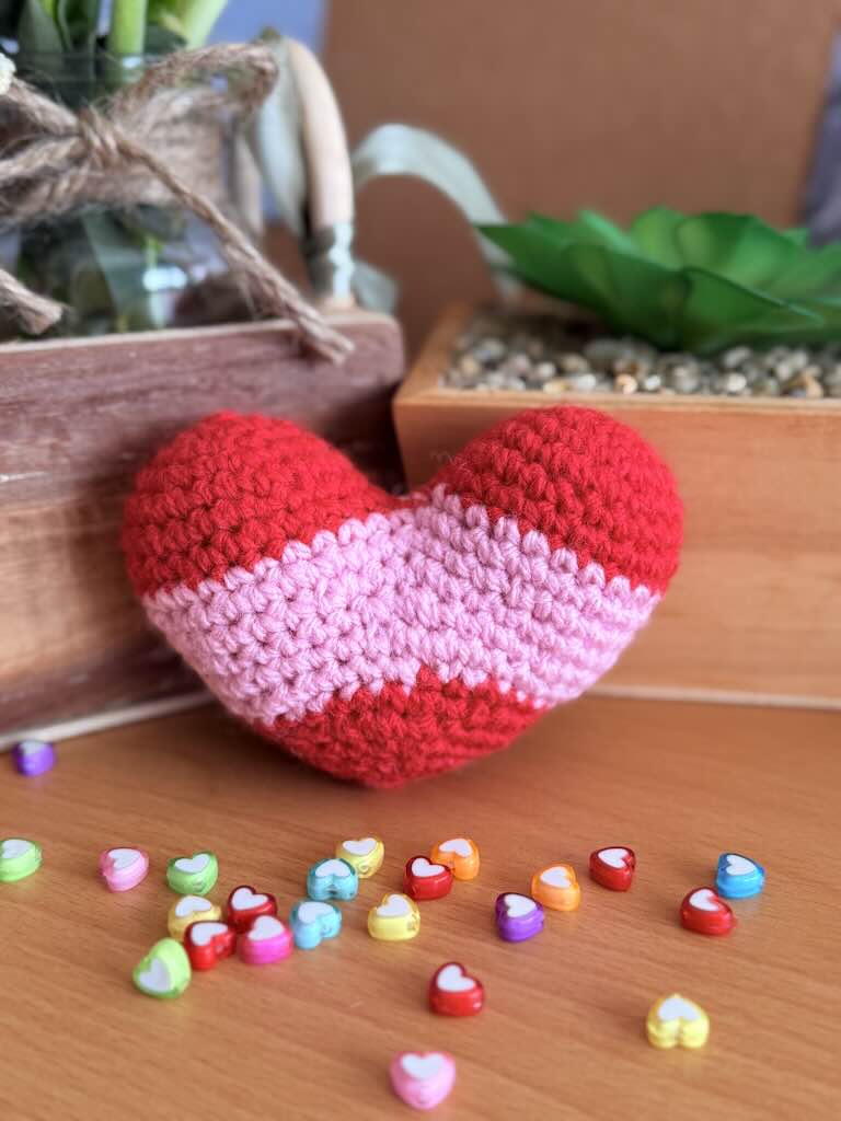 handmade crochet heart in pink and red stripes, perfect for gifting