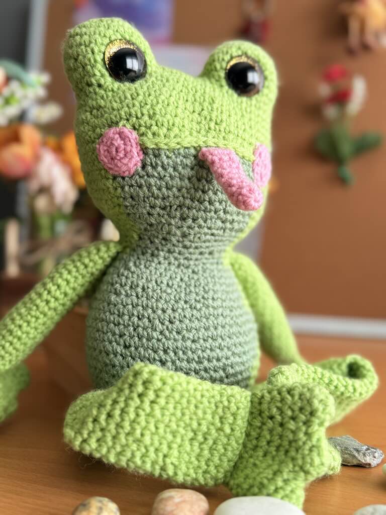 handmade crochet frog toy named Flipper with big eyes and pink tongue