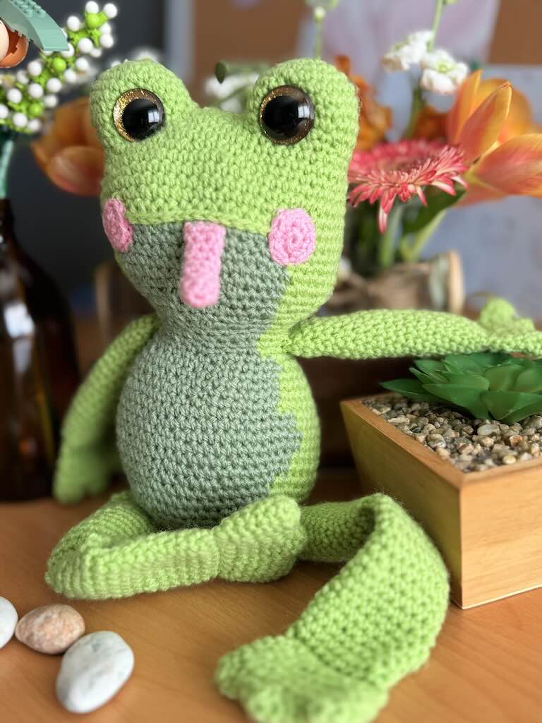 handmade crochet frog toy named Flipper with big eyes and pink tongue