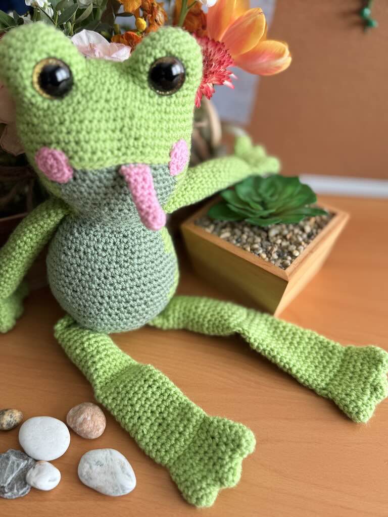 handmade crochet frog toy named Flipper with big eyes and pink tongue