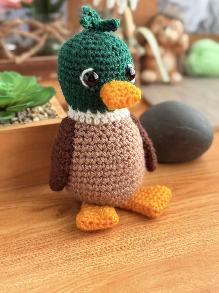 handmade crochet duck toy named Mervin with green head, yellow beak and feet to match
