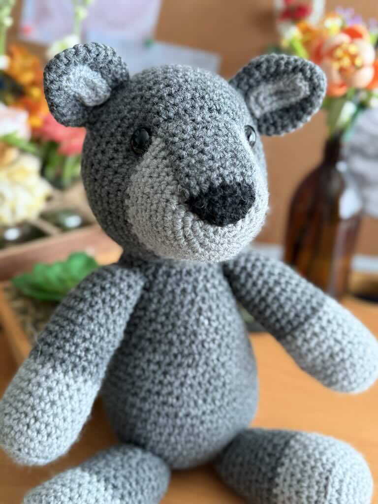 handmade crochet fox toy named Felix with a bright grey body and bushy tail
