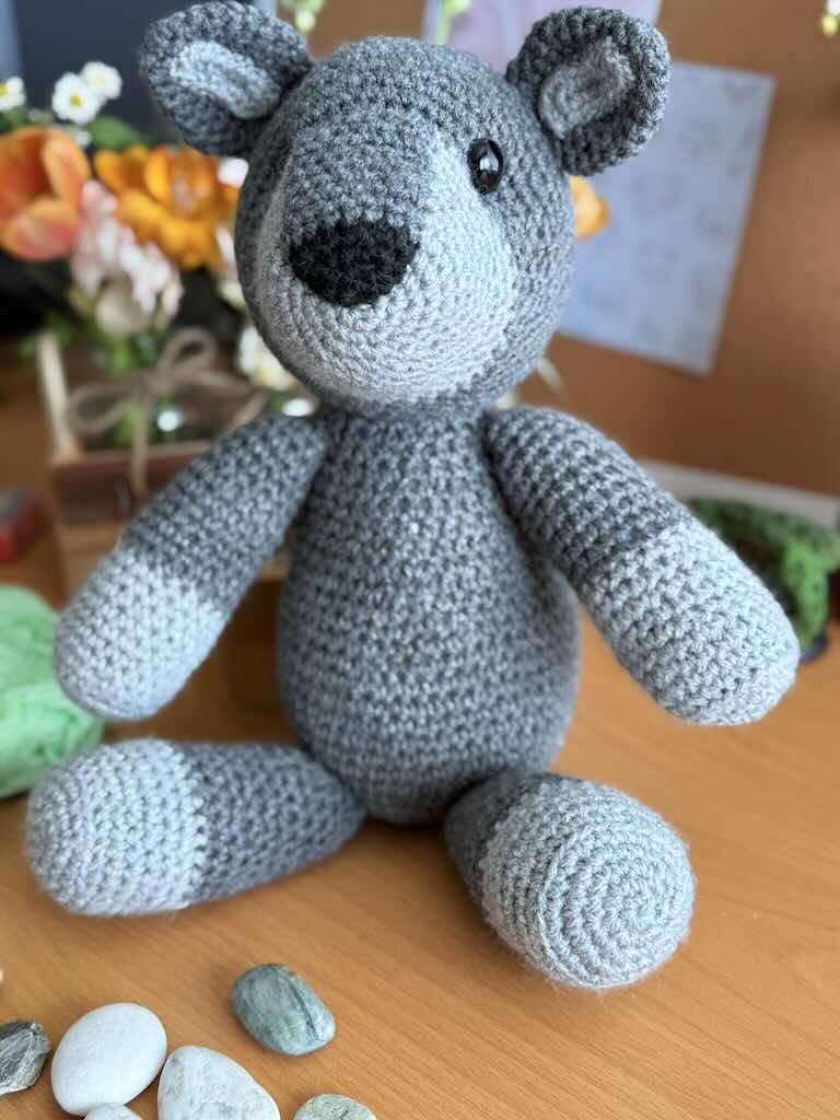 handmade crochet fox toy named Felix with a bright grey body and bushy tail