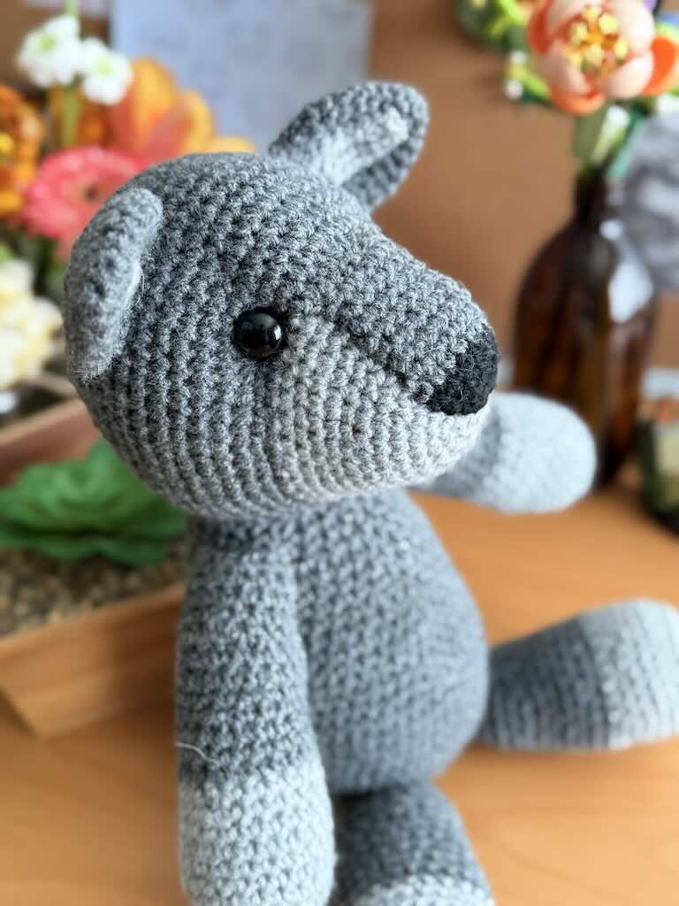 handmade crochet fox toy named Felix with a bright grey body and bushy tail