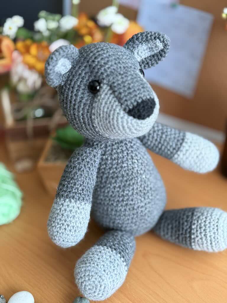 handmade crochet fox toy named Felix with a bright grey body and bushy tail