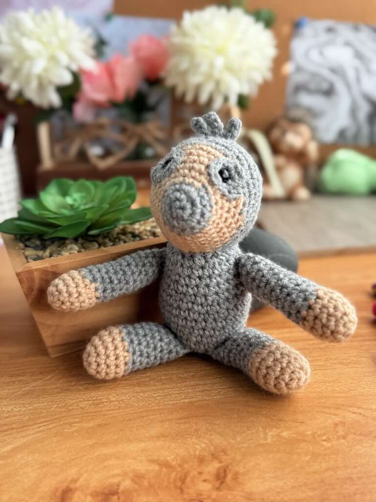 handmade crochet sloth toy named Samuel with sleepy smile and long arms